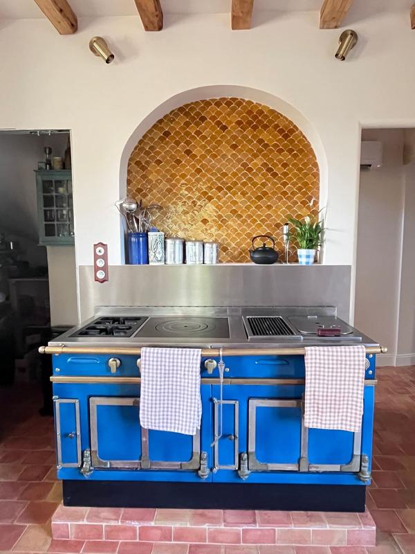 Le piano de cuisson bleu sous l'arche en zellige doré
